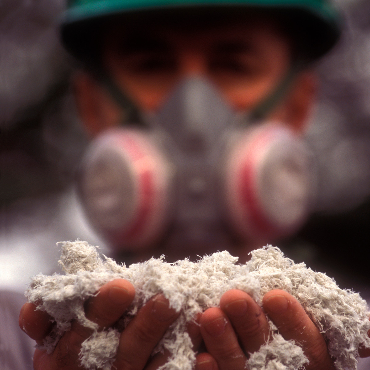 BOHS-qualified asbestos surveyor in full protective equipment conducting sensitive healthcare environment inspection