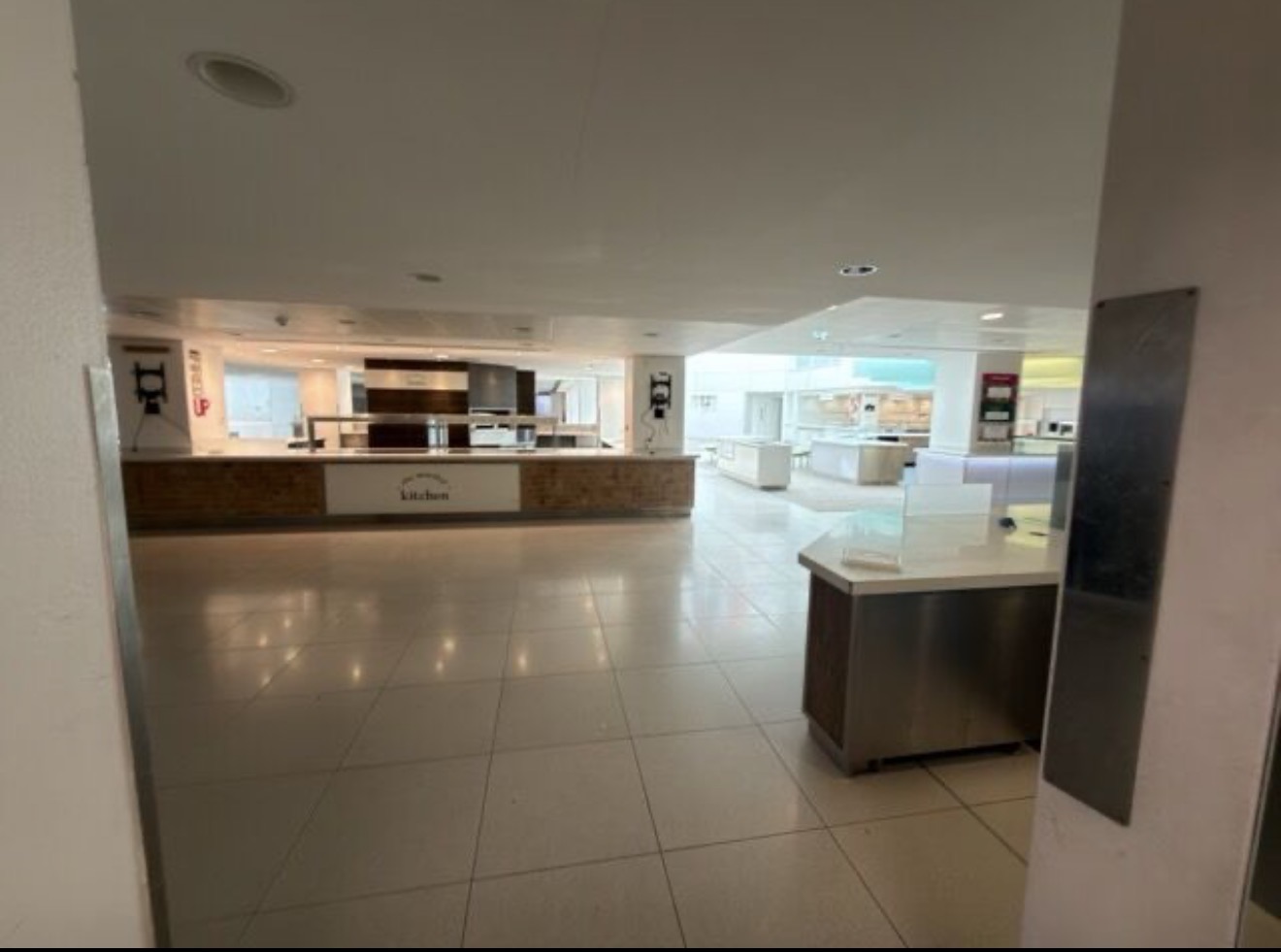 Former catering servery inside One Silk Street with white counters and a tiled floor
