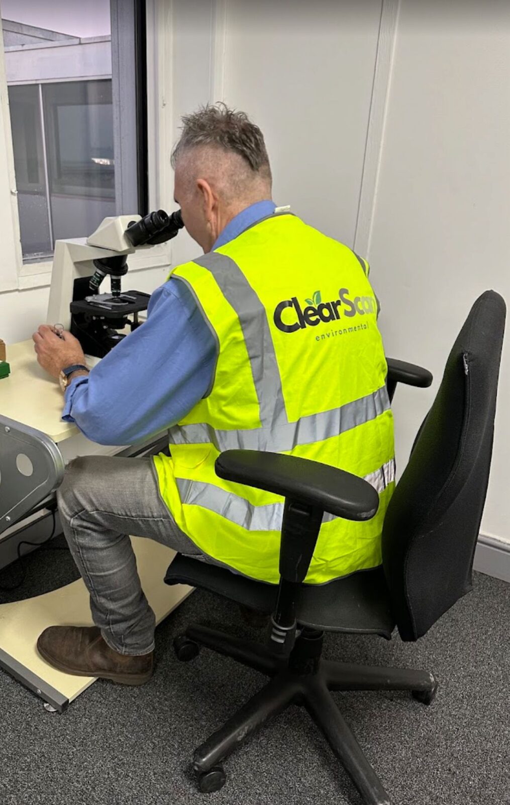 Professional air monitoring equipment and operative conducting asbestos clearance testing at utilities facility